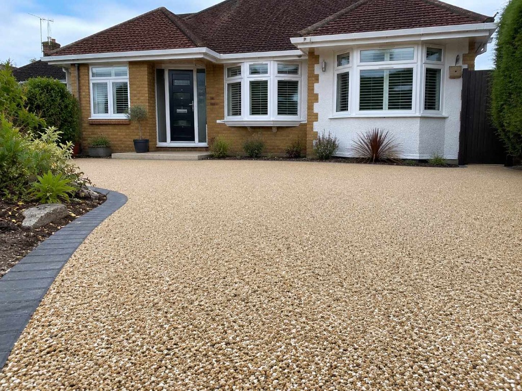 Caramel Latte resin bound driveway on bungalow with curved border detail by Daltex Resin Experts