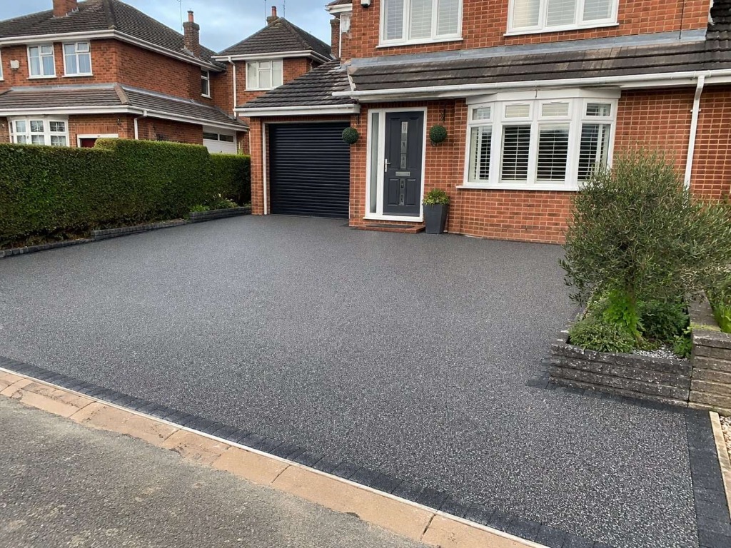 Dark Grey resin bound driveway on semi-detached red brick property by Daltex Resin Experts